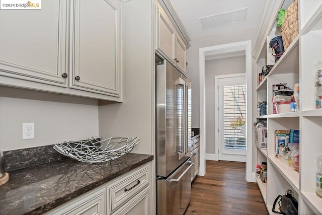 kitchen with dark hardwood / wood-style flooring, high end fridge, and dark stone countertops