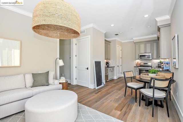 living room with hardwood / wood-style flooring and crown molding