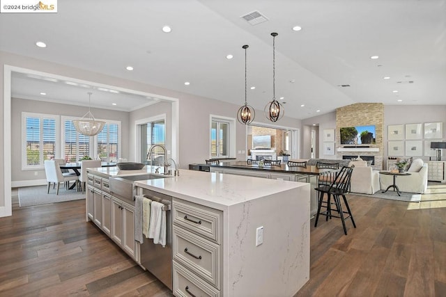 kitchen featuring a large island with sink, dishwasher, dark hardwood / wood-style floors, and vaulted ceiling