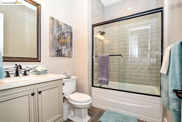 full bathroom with tile patterned flooring, vanity, toilet, and shower / bath combination with glass door