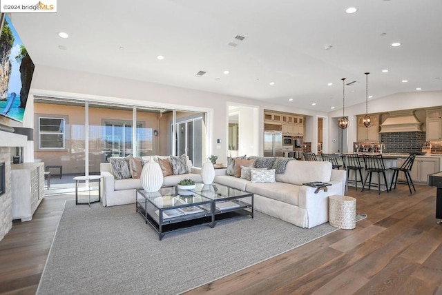 living room featuring dark hardwood / wood-style floors and vaulted ceiling