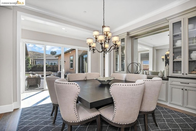 dining room with a chandelier, crown molding, and dark wood-type flooring