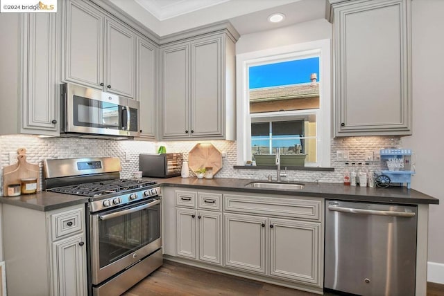 kitchen with appliances with stainless steel finishes, tasteful backsplash, crown molding, and sink