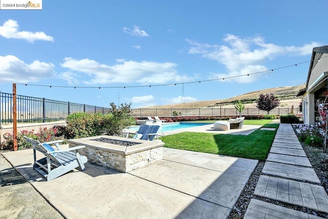 view of patio with a mountain view, a fenced in pool, and an outdoor fire pit