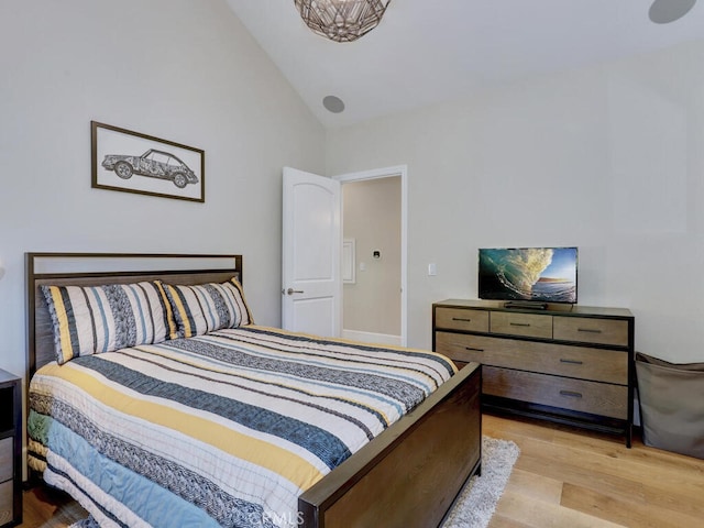 bedroom with light hardwood / wood-style flooring and lofted ceiling