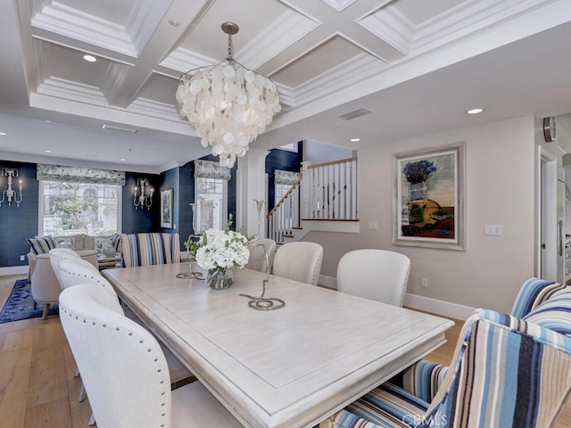 dining area featuring coffered ceiling, crown molding, light wood-type flooring, beam ceiling, and a chandelier