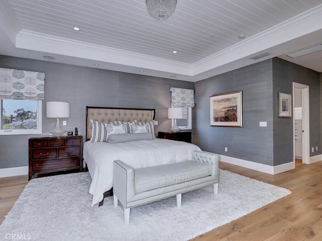 bedroom featuring light wood-type flooring, ornamental molding, wood ceiling, and a tray ceiling