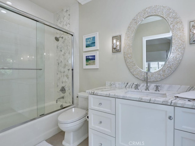 full bathroom featuring vanity, toilet, and bath / shower combo with glass door