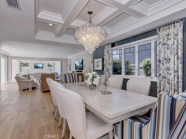 dining space featuring beam ceiling, coffered ceiling, an inviting chandelier, crown molding, and light wood-type flooring