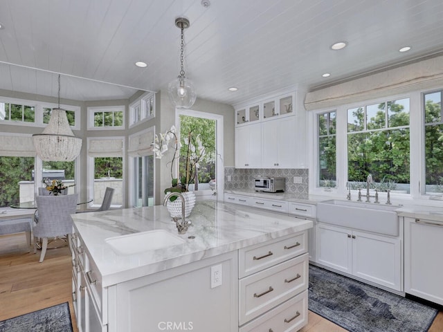 kitchen with white cabinets, pendant lighting, and sink