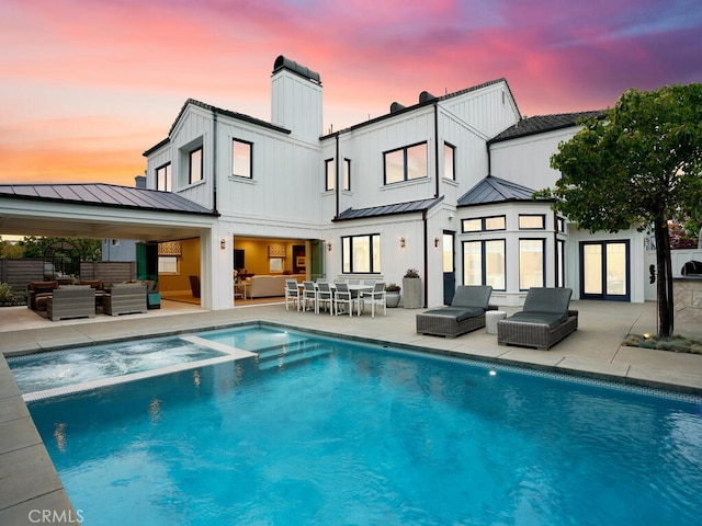 back house at dusk featuring a patio area and an outdoor hangout area