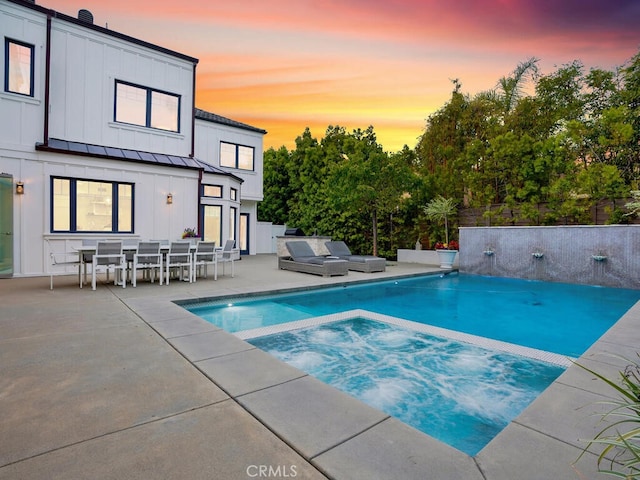 pool at dusk featuring a patio area