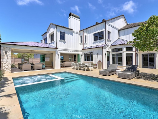 back of property with an outdoor living space and a patio area