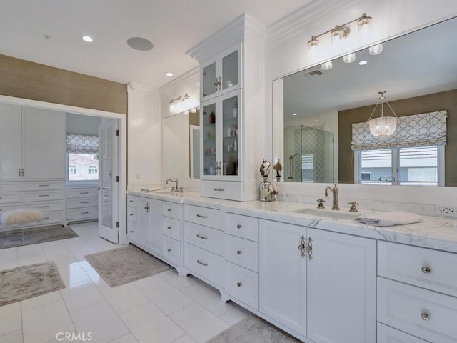 bathroom featuring tile patterned flooring, vanity, ornamental molding, and walk in shower