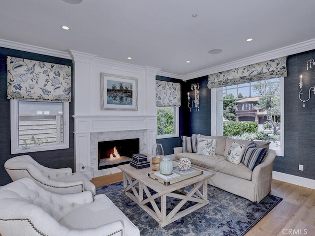 living room featuring hardwood / wood-style flooring, crown molding, and a high end fireplace