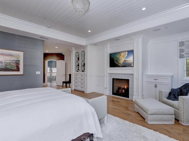 bedroom with ornamental molding, wood ceiling, and light wood-type flooring