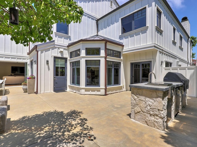 back of house with area for grilling and a patio