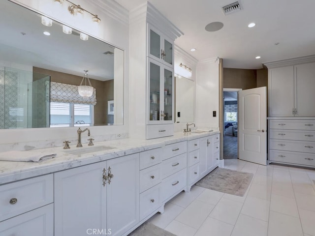 bathroom featuring tile patterned floors, crown molding, vanity, and walk in shower