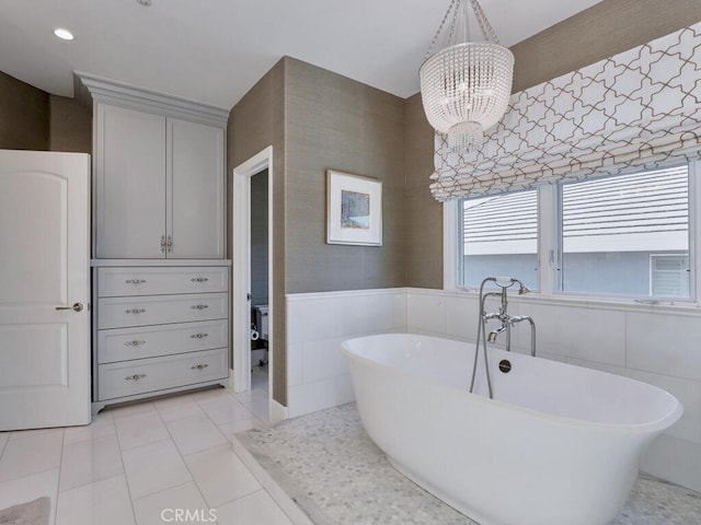 bathroom featuring tile patterned floors, a washtub, and a chandelier