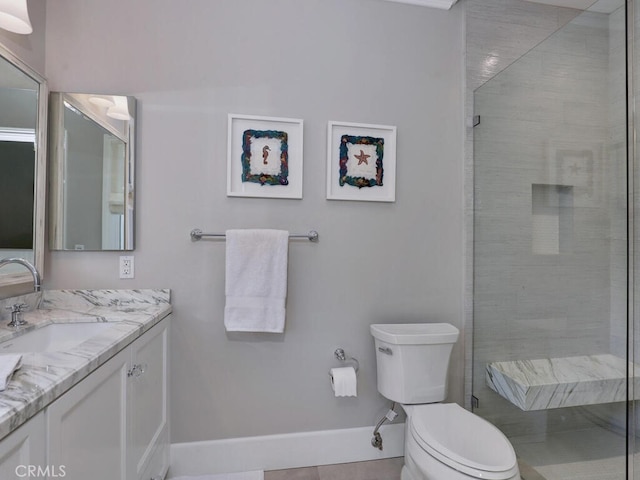 bathroom with tile patterned floors, vanity, tiled shower, and toilet