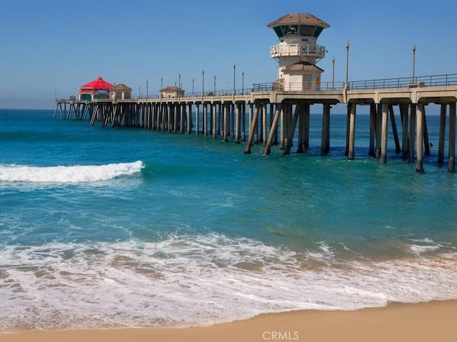 dock area featuring a water view and a beach view