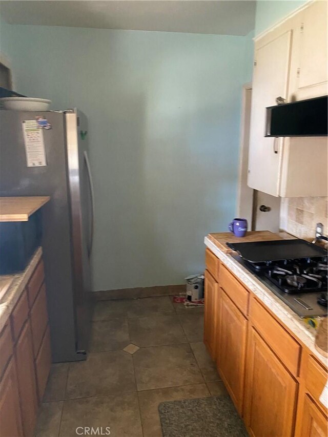 kitchen featuring stainless steel refrigerator and tile patterned floors