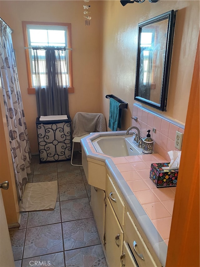 bathroom with decorative backsplash, tile patterned floors, and vanity