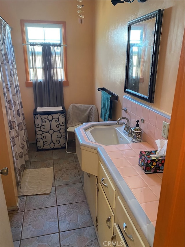 bathroom with vanity, tile patterned floors, and backsplash