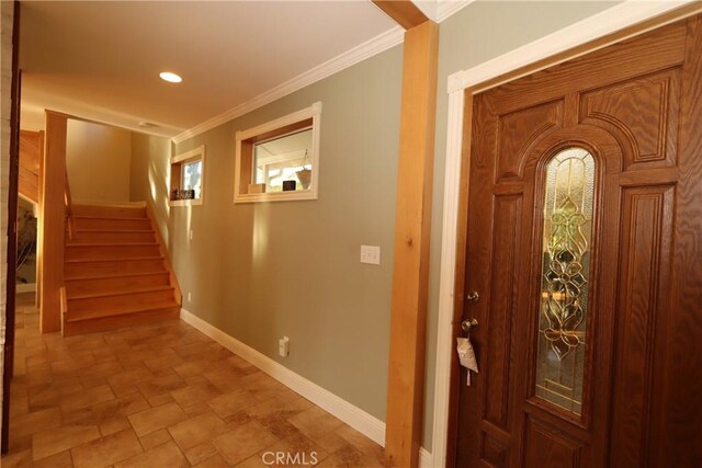 tiled foyer entrance featuring crown molding