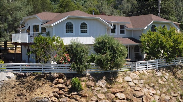 view of front of home featuring a balcony and a fenced front yard