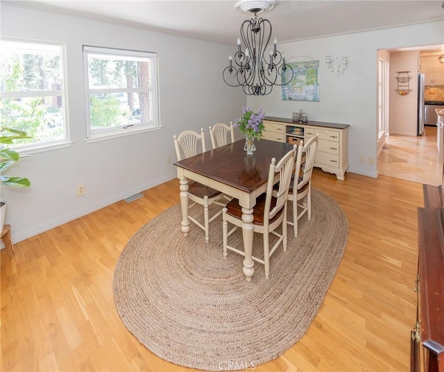 dining area with a notable chandelier and light wood-type flooring