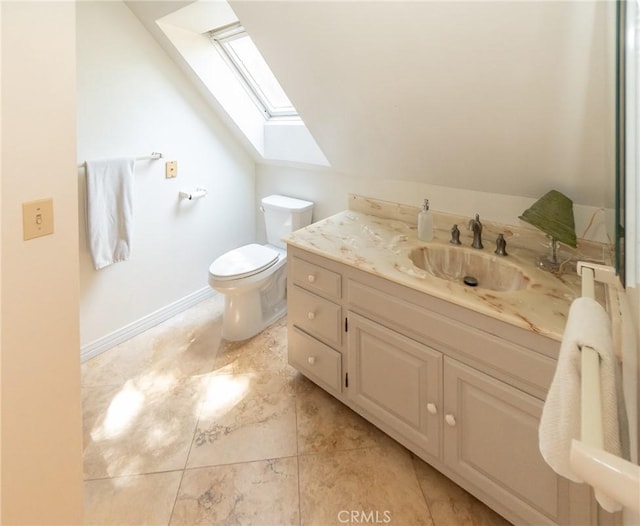 bathroom with tile patterned flooring, vanity, toilet, and a skylight