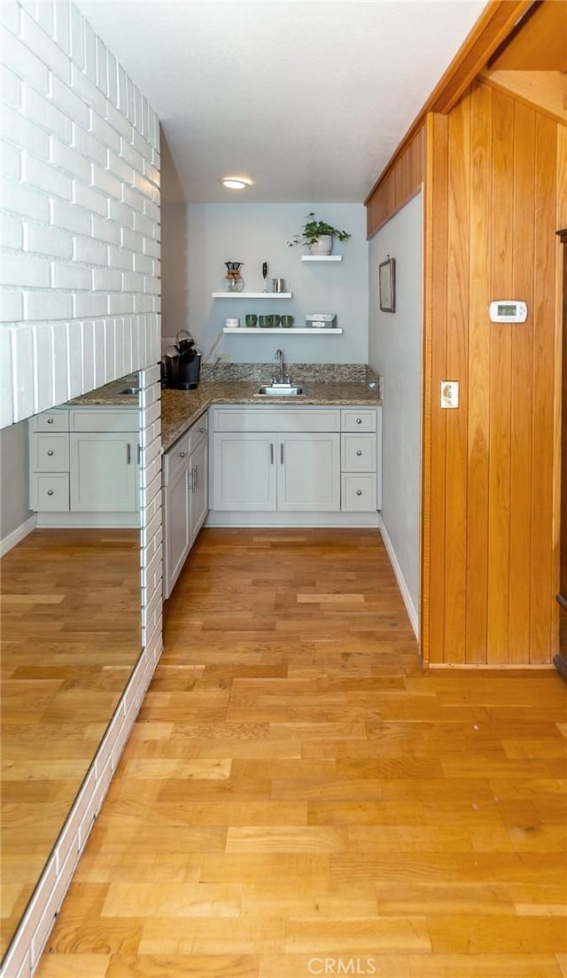 kitchen with light hardwood / wood-style floors, white cabinetry, and sink