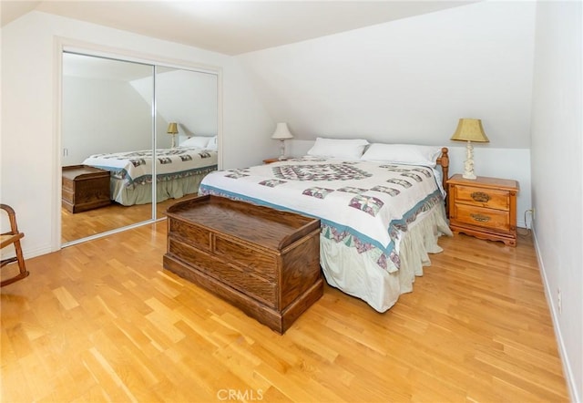 bedroom with a closet, lofted ceiling, and hardwood / wood-style flooring