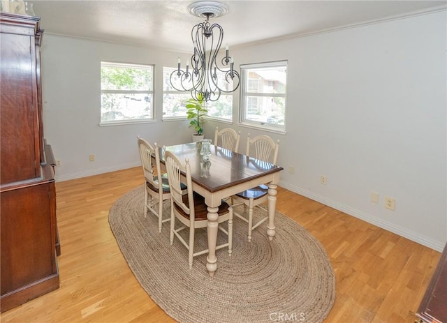 dining room with a chandelier, light hardwood / wood-style flooring, a wealth of natural light, and crown molding