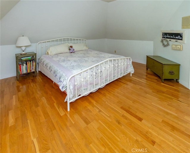 bedroom featuring hardwood / wood-style flooring and vaulted ceiling