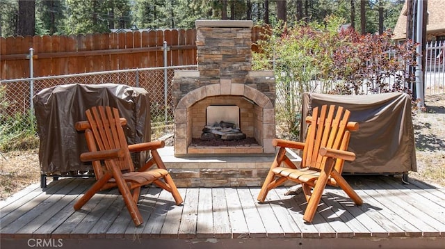 wooden terrace featuring an outdoor stone fireplace