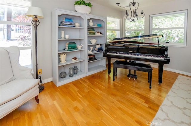 misc room with hardwood / wood-style floors, plenty of natural light, and a notable chandelier