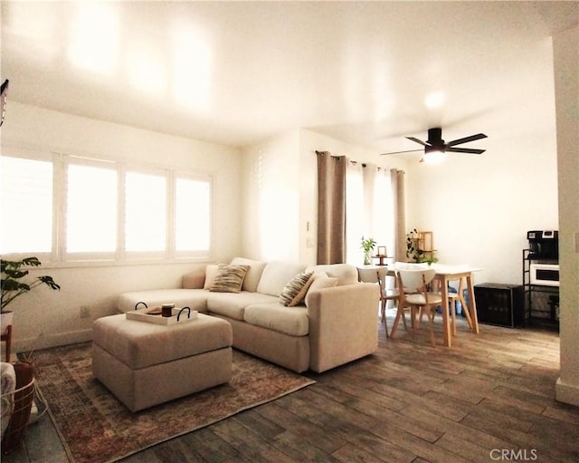 living room featuring ceiling fan and dark hardwood / wood-style floors