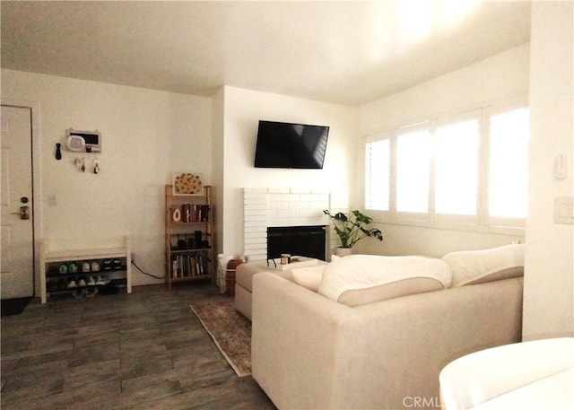 living room featuring dark hardwood / wood-style floors and a brick fireplace