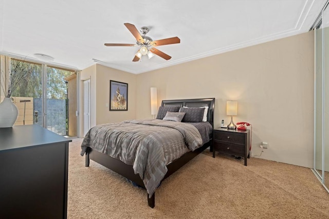 carpeted bedroom with ceiling fan, access to exterior, and crown molding