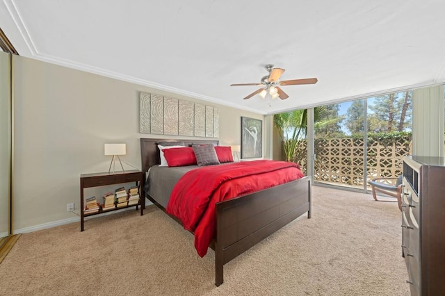 carpeted bedroom with ceiling fan, a wall of windows, and ornamental molding