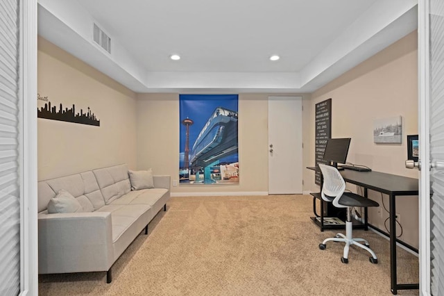 carpeted home office with a tray ceiling