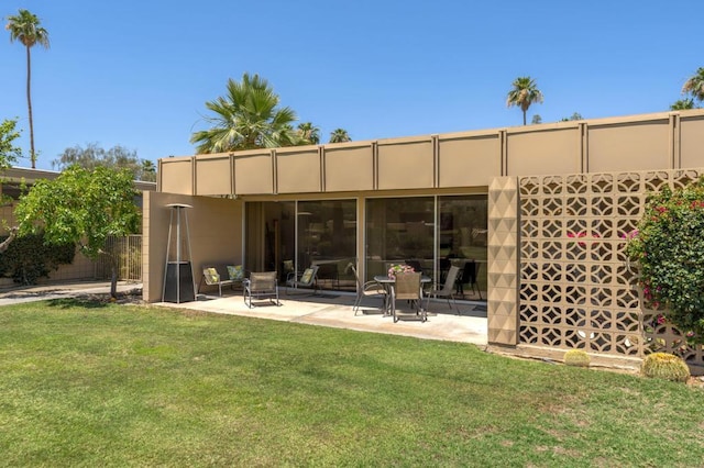 rear view of property featuring a patio area and a yard