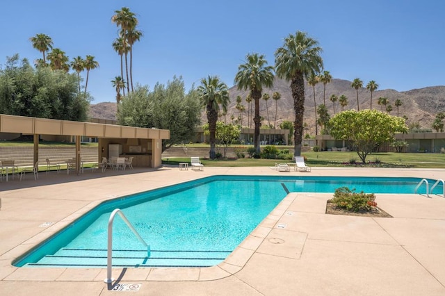 view of swimming pool featuring a mountain view and a patio area