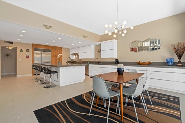 tiled dining area featuring a chandelier and sink