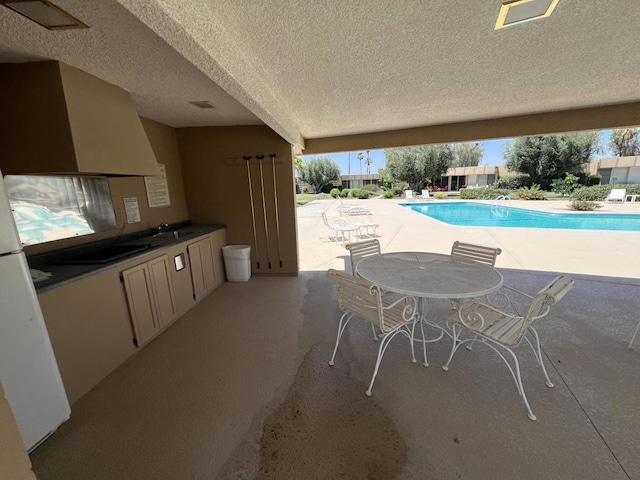 view of swimming pool with a patio area and sink