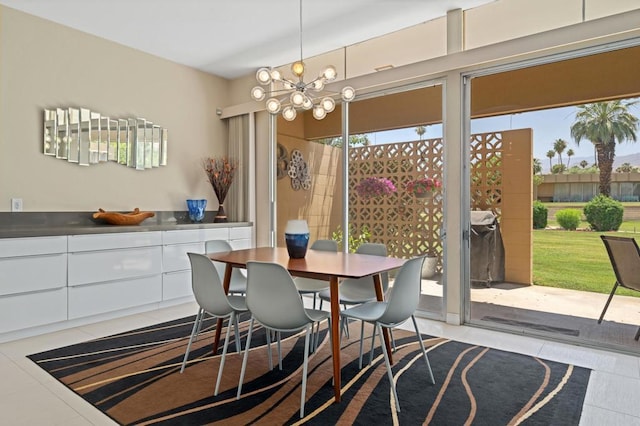 dining area with light tile patterned flooring and an inviting chandelier