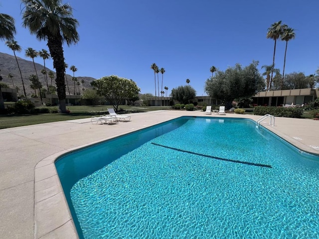 view of swimming pool featuring a mountain view and a patio