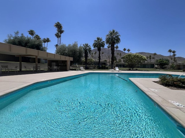 view of swimming pool with a mountain view and a patio